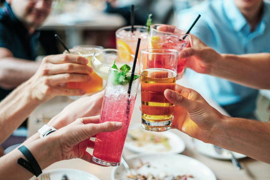 a group of people toasting with drinks at a restaurant for a birthday part celebration sharing drinks and creating cherished memories. after karaoke in tesla cruising in perth australia  