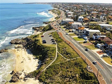 an aerial view of houses and the ocean in Scarborough beach perth australia while cruising in tesla car and signing karaoke